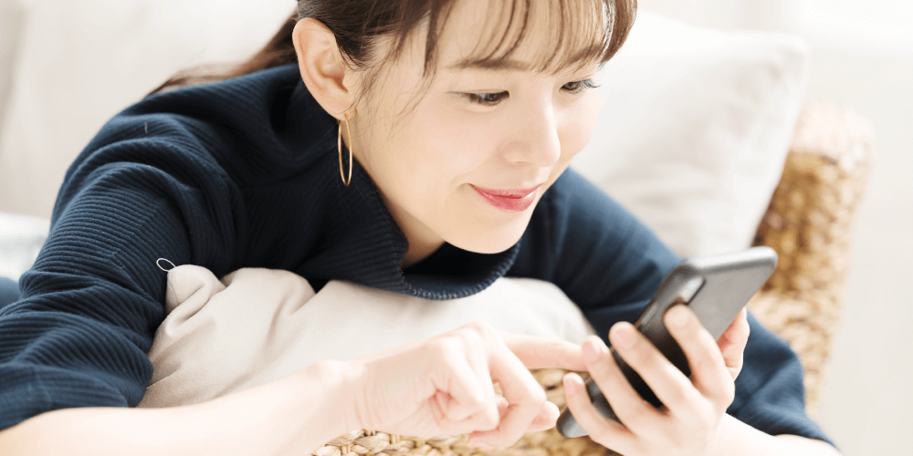 スマートフォンで本を読む女性